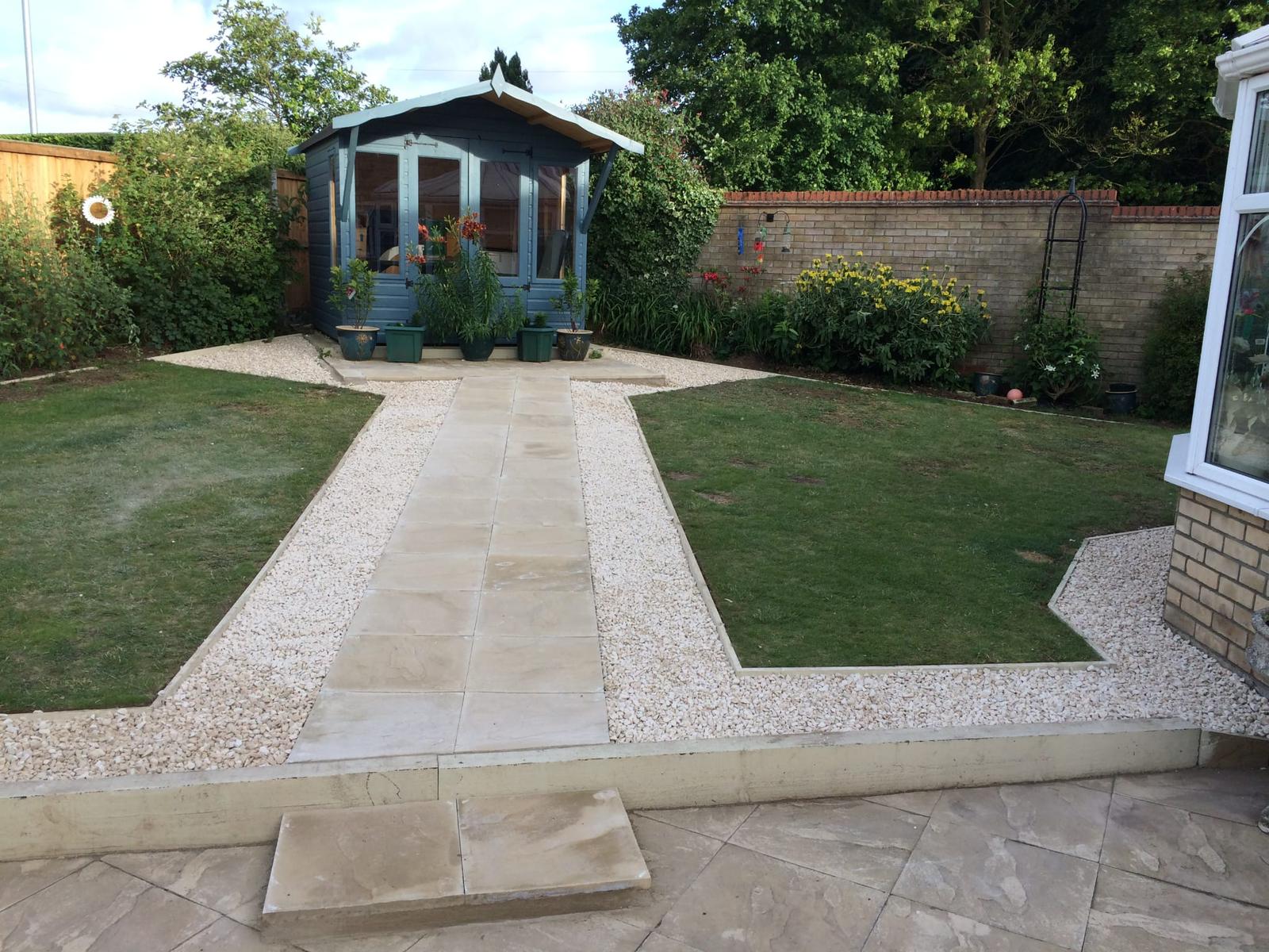 This is a newly installed slab pathway with a shingle border installed to a garden shed